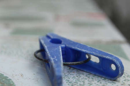 Blue clothespin on a white background.
