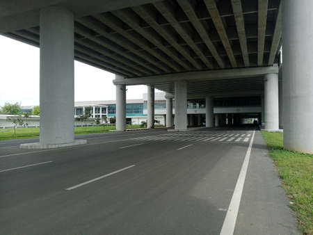 Asphalt road under the expressway with modern building in the background