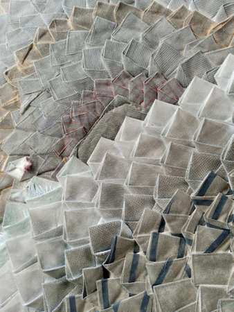 A closeup shot of a pile of grey textured tiles