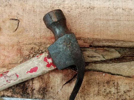 Hammer on a wooden background. Old rusty hammer on a wooden background.