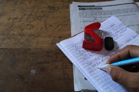 Hand with pen writing on a notebook