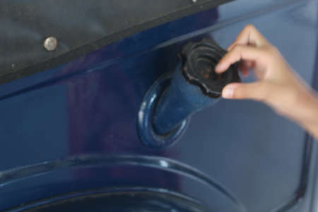 Close-up of the hands of a man cleaning a washing machineの写真素材