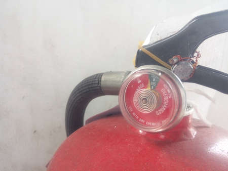 Red fire extinguisher with pressure gauge on white background, close upの写真素材