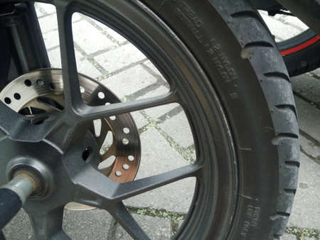 A closeup shot of a wheel of a motorcycle with a blurred background
