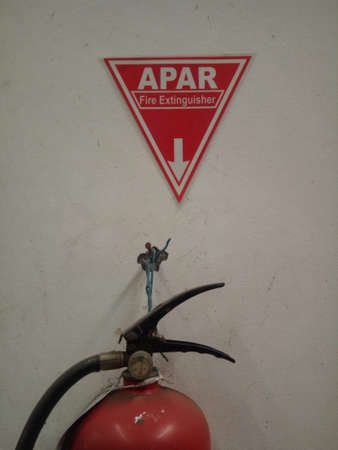 Fire extinguisher on the wall of a building.の写真素材