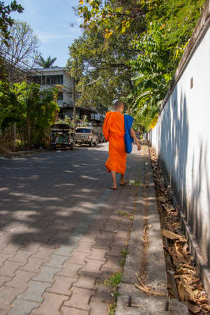 14.11.2011, Chiangmai, Thailand. A monk walks along a street in the northern Thai city of Chiangmaiのeditorial素材