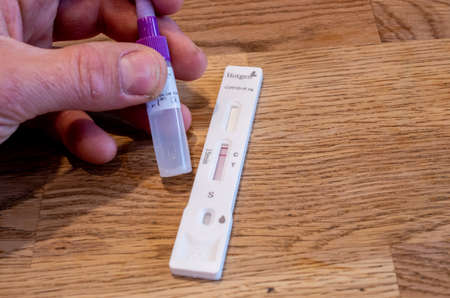 Bamberg, Germany - 8.4.2021. Hand with Corona self-test kit from Hotgen.のeditorial素材