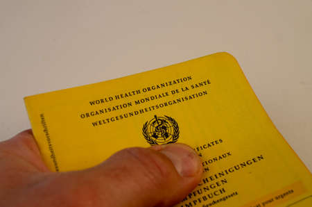 Bamberg, Germany - 14-05.2021. Hand with vaccination pass against a white backgroundのeditorial素材