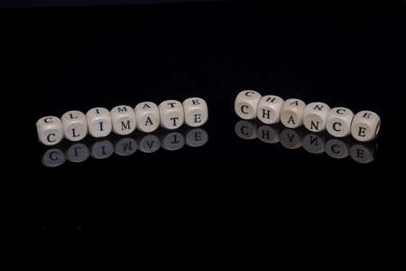Letter cubes form the words Climate Chance against a black, reflective background