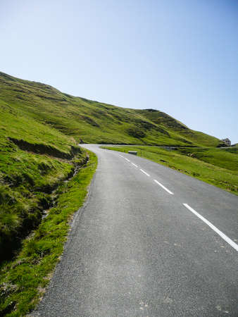 Mountain road surrounded by green meadows through the French Pyreneesの写真素材