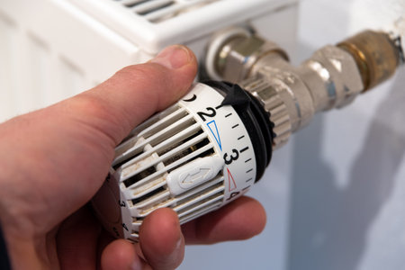 Male hand turns a radiator thermostatの写真素材