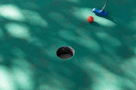 Somebody is playing minigolf with a red ball. Mini golf recreationの写真素材