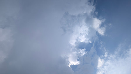 A captivating view of the sky presents a stunning contrast between dark, heavy clouds and luminous...