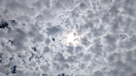 A captivating shot of sunlight trying to break through a thick layer of clouds. The sky is filled...