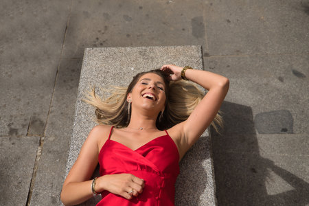 Young, attractive and blonde woman, with cashmere shirt, green pants and sunglasses, walking around making balances in a fun way along a line on the floor. Concept beauty, fashion, trend, fun.の写真素材