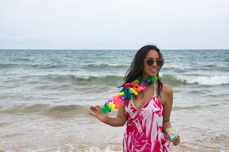 South American woman, young and beautiful, brunette with sunglasses and bikini stroking her hair happily on the beach. Concept sea, sand, sun, beach, vacation, travel, summer.の写真素材