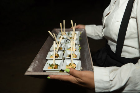 Presentation of small containers with mussels, allioli and parsley on a tray during a catering. Food concept, menu, catering.の写真素材