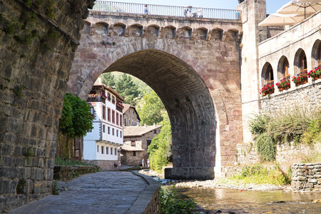 The new bridge is the main bridge of the town of Potes. Authentic viaduct that saves the waters of the Quiviesa river that is approaching its end, flowing a few meters downstream into the Deva river.の写真素材