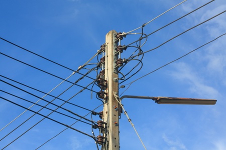 Electric post with cable and light on the day with blue sky