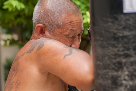 The old man practicing boxing, his body full of tattooの写真素材