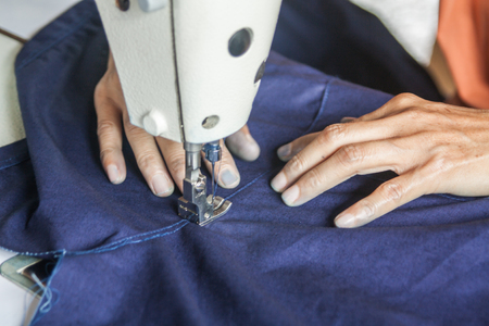 A woman housewife sewing traditional dress as a hobbyの写真素材
