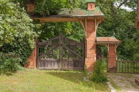 Wooden ramshackle gate with brick columnsの写真素材