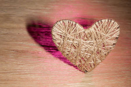 heart made of flax on the background of an oak boardの写真素材