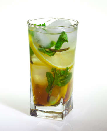 drops of rose on a glass of cold drink with ice, lemon and mint on a white backgroundの写真素材