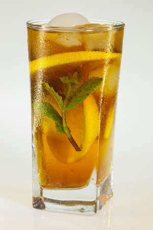 drops of rose on a glass of cold drink with ice, lemon and mint on a white backgroundの写真素材