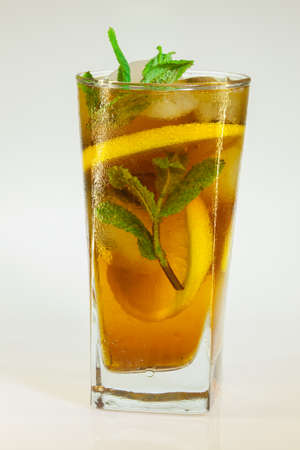 drops of rose on a glass of cold drink with ice, lemon and mint on a white backgroundの写真素材