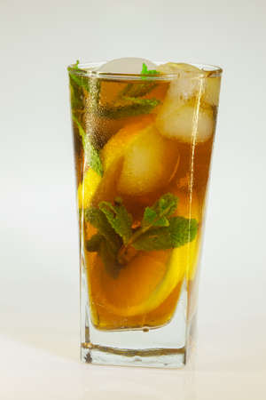 drops of rose on a glass of cold drink with ice, lemon and mint on a white backgroundの写真素材