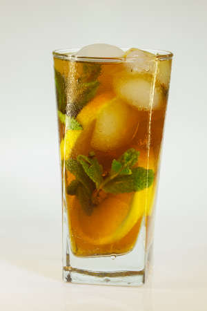 drops of rose on a glass of cold drink with ice, lemon and mint on a white backgroundの写真素材