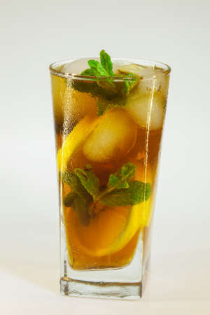 drops of rose on a glass of cold drink with ice, lemon and mint on a white backgroundの写真素材
