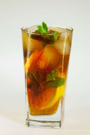 drops of rose on a glass of cold drink with ice, lemon and mint on a white backgroundの写真素材