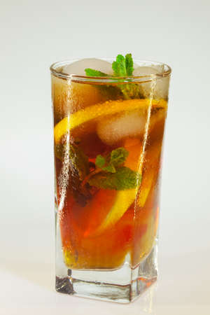 drops of rose on a glass of cold drink with ice, lemon and mint on a white backgroundの写真素材