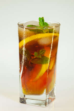 drops of rose on a glass of cold drink with ice, lemon and mint on a white backgroundの写真素材