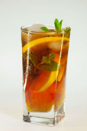 drops of rose on a glass of cold drink with ice, lemon and mint on a white backgroundの写真素材