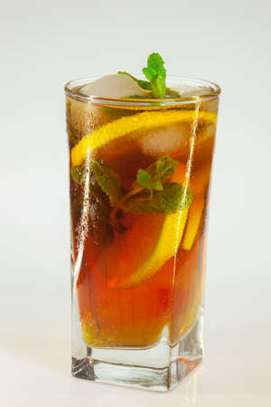 drops of rose on a glass of cold drink with ice, lemon and mint on a white backgroundの写真素材