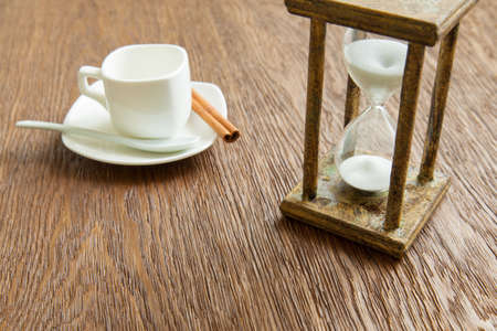 Hourglass on the Oak table as time passing concept for business deadline, urgency and running out of time.の写真素材