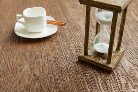 Hourglass on the Oak table as time passing concept for business deadline, urgency and running out of time.の写真素材