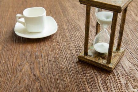 Hourglass on the Oak table as time passing concept for business deadline, urgency and running out of time.の写真素材