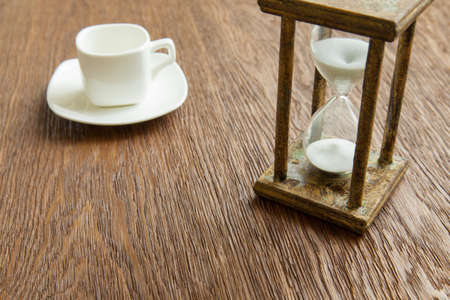 Hourglass on the Oak table as time passing concept for business deadline, urgency and running out of time.の写真素材