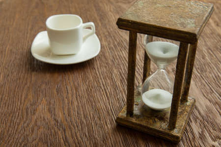 Hourglass on the Oak table as time passing concept for business deadline, urgency and running out of time.の写真素材