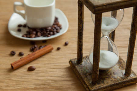 Hourglass on the Oak table as time passing concept for business deadline, urgency and running out of time.の写真素材
