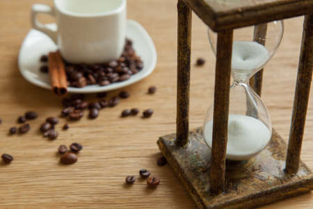 Hourglass on the Oak table as time passing concept for business deadline, urgency and running out of time.の写真素材