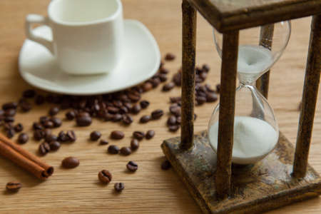 Hourglass on the Oak table as time passing concept for business deadline, urgency and running out of time.の写真素材