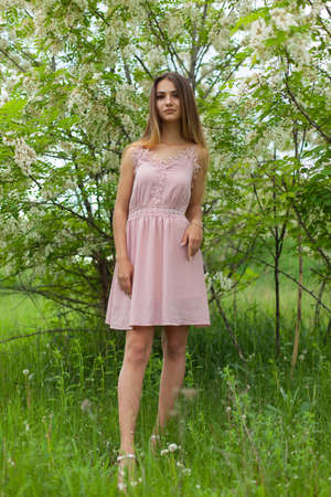 sexual girl has dissolved long hair sunny in the afternoon opposite blossoming white acaciaの写真素材