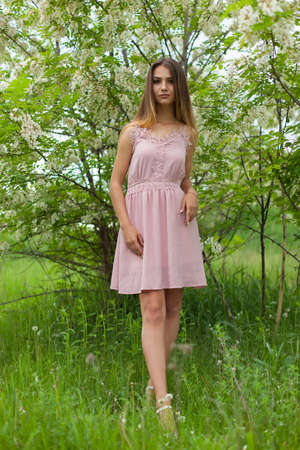 sexual girl has dissolved long hair sunny in the afternoon opposite blossoming white acaciaの写真素材
