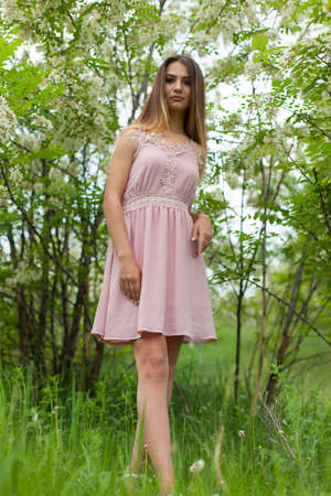 sexual girl has dissolved long hair sunny in the afternoon opposite blossoming white acaciaの写真素材