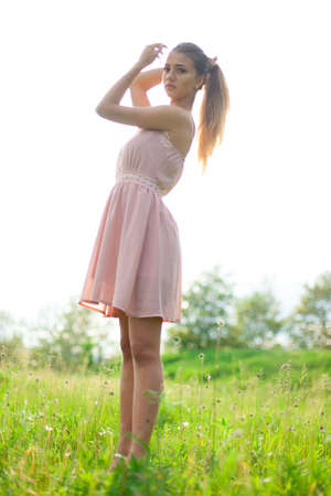 sexual girl has dissolved long hair sunny in the afternoon opposite blossoming white acaciaの写真素材